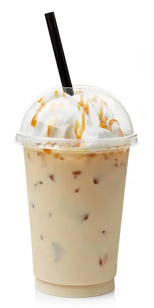 Iced caramel coffee covered with whipped cream in plastic glass isolated on white background