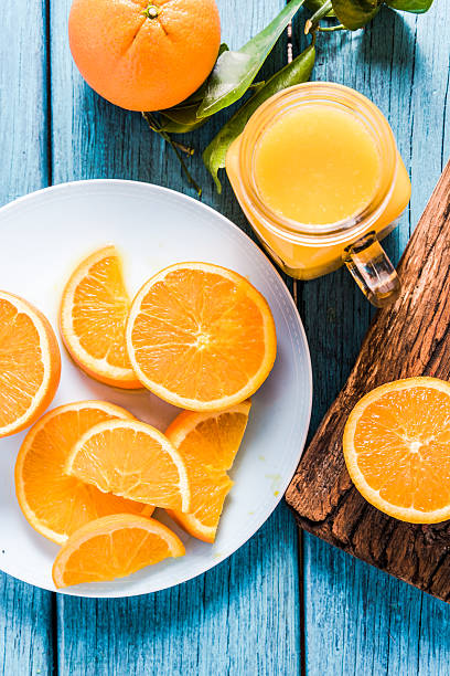 jovem mão pressionada e colocada sumo de laranja - freshly squeezed orange juice imagens e fotografias de stock