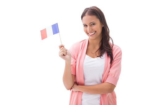 Pretty brunette smiling and holding french flag on white background