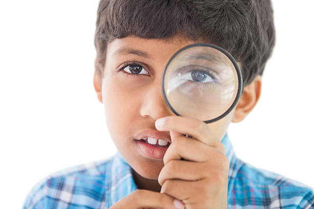 istock Cute boy looking through a magnifying glass 518019565
