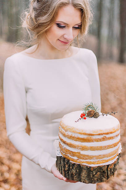 istock Attractive blonde bride with wedding cake in the autumn forest 518019772