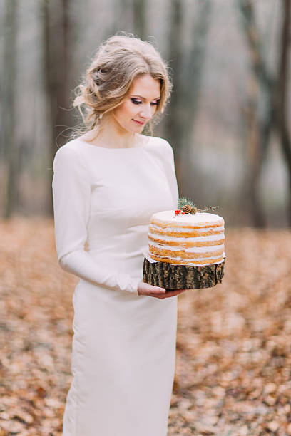 istock Attractive blonde bride with wedding cake in the autumn forest 518019826