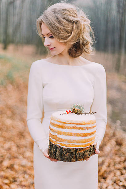 istock Attractive blonde bride with wedding cake in the autumn forest 518019896
