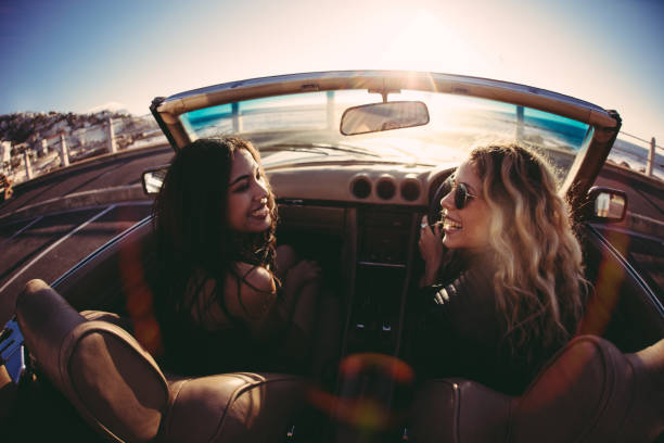 istock Young women having fun in convertible on seaside at sunset 518019974