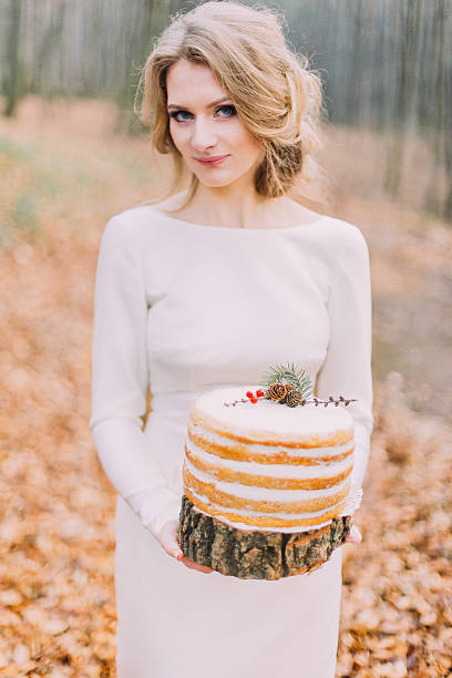 istock Attractive blonde bride with wedding cake in the autumn forest 518020042