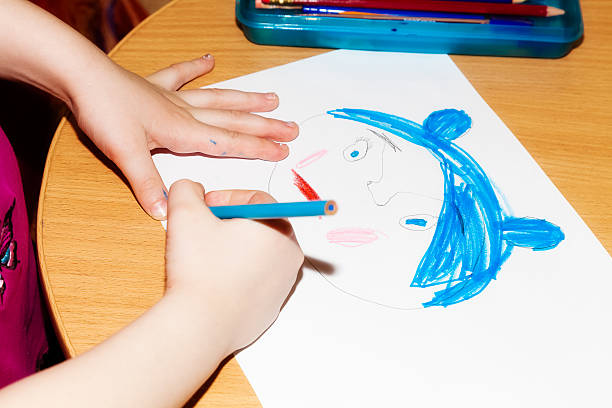 istock Child's hands drawing a picture on paper 518021414