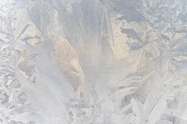 Photo of Ice floral pattern on glass in blurred vignette. Macro view.