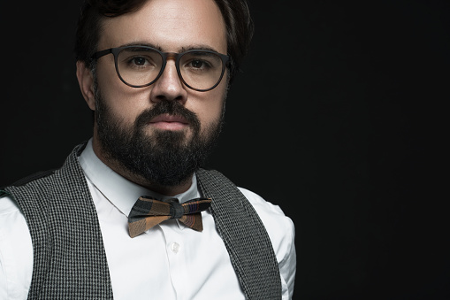 Portrait of hipster businessman over black background. Image taken with Sony A7RII camera system and developed from camera RAW.