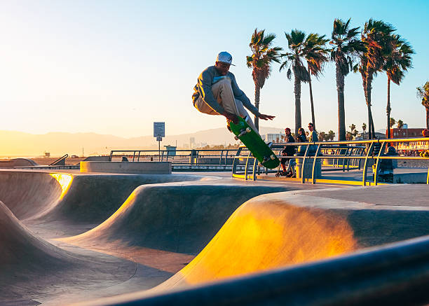 Venice beach, California, USA - May 03, 2015: young man skateboarding at sunset on skatepark in Venice Beach