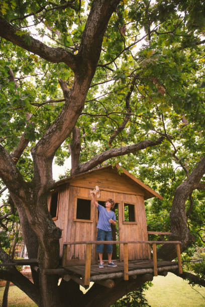 istock Boy playing with a wooden toy plane in a treehouse 518025266