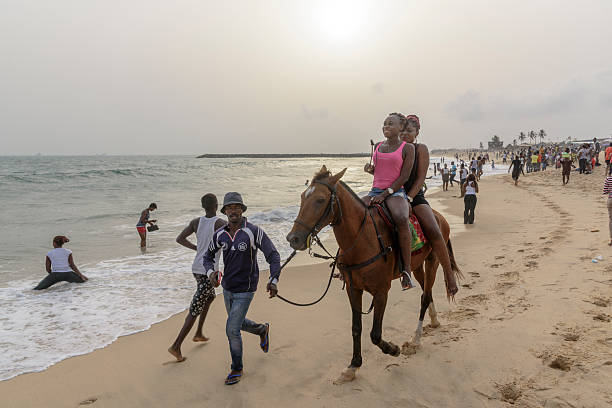 Woman ride horses in the water on the beach