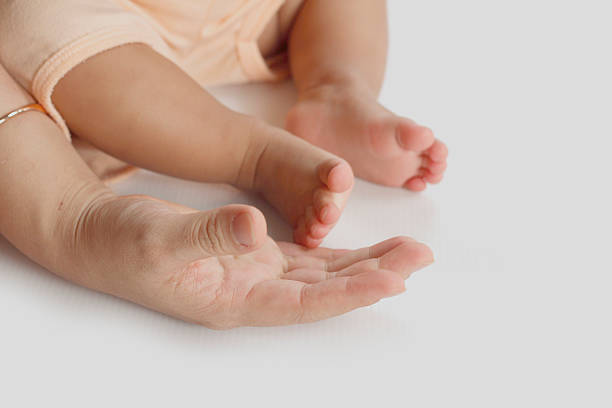 istock mother's hand hold a little baby's foot 518025828