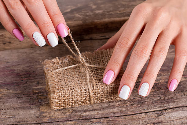 istock Women's hands with a nice manicure unleash a gift. 518027148