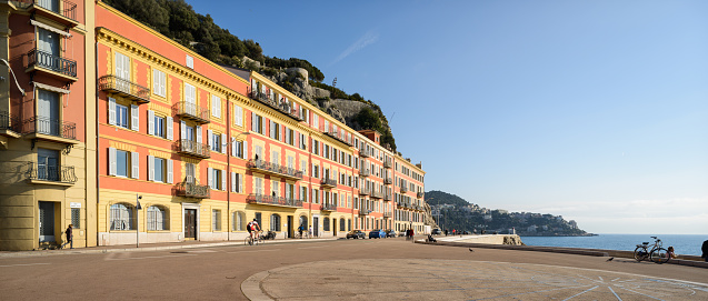 Part of the promenade of the old town of Nice, with beautiful apartment buildings overlooking the Mediterranean Sea. It's a beautiful sunny day, Nice, Cote d'Azur, south of France. Panoramic 16:9 format image.