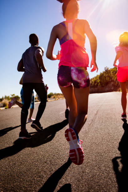 istock Athletic girl running outdoors with friends 518032162