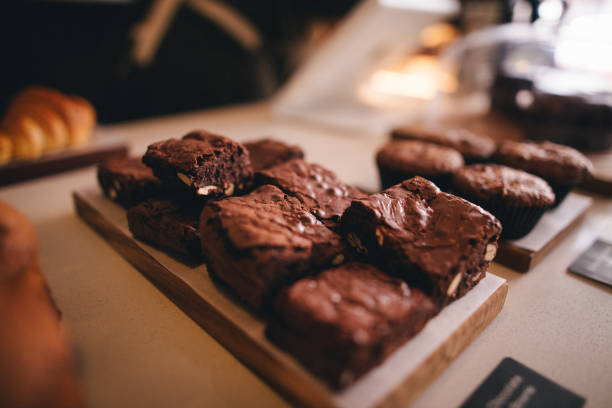 A brownie display on front counter of trendy coffee shop with muffin display beside them