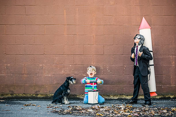 Teamwork Two boys and the dog having fun with a rocket. scientific exploration stock pictures, royalty-free photos & images