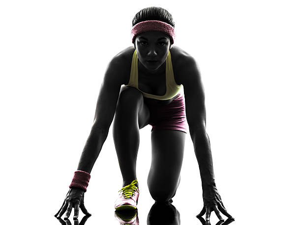 istock woman runner running on starting blocks silhouette 518038293