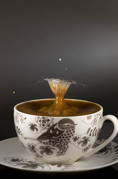 tasse à café avec goutte de lait landing dans le café - water surface emotional stress shape nature photos et images de collection