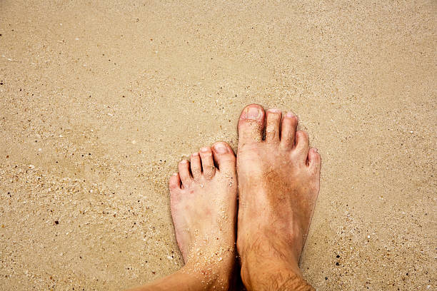 istock feet of a man in the fine sand 518041993