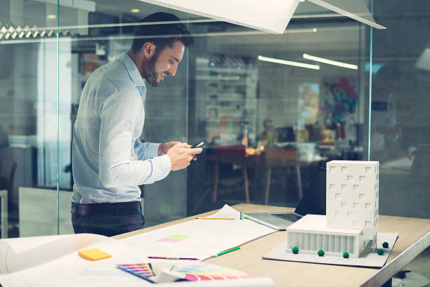 istock Designer typing on smart phone in office. 518044807