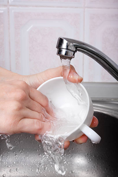 istock hands washing a cup, closeup 518054960