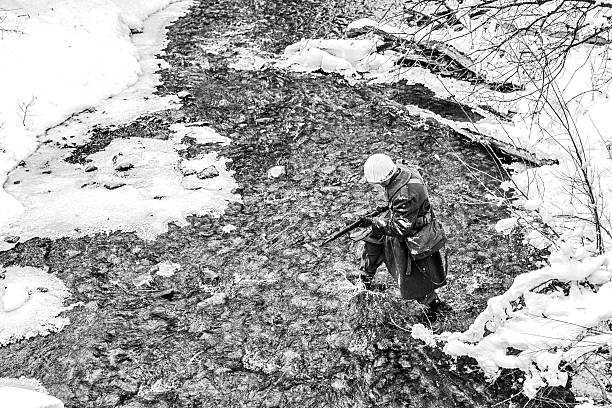 istock World War II: Soldier Crossing Creek in the Snow 518057180