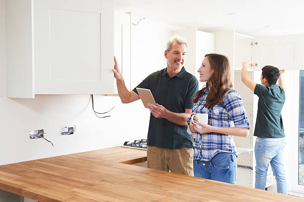 istock Woman With Carpenter Looking At Plans For Kitchen 518059656