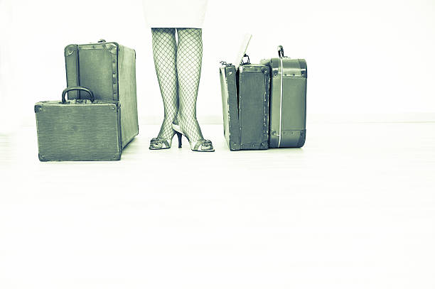 istock Retro Traveling - Woman standing beside suitcases 518059782