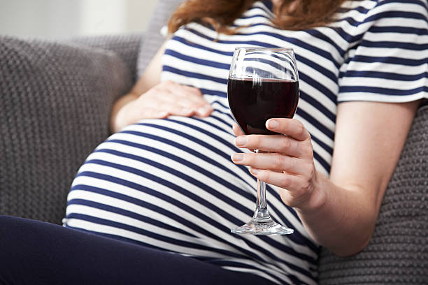 Close Up Of Pregnant Woman Drinking Red Wine stock photo