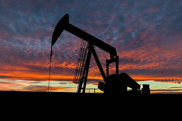 ciel dramatique sur gréer silhouette dans rural alberta, canada - oil pumping unit at sunset time photos et images de collection