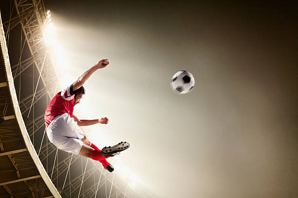 istock Athlete kicking soccer ball in stadium 518064288