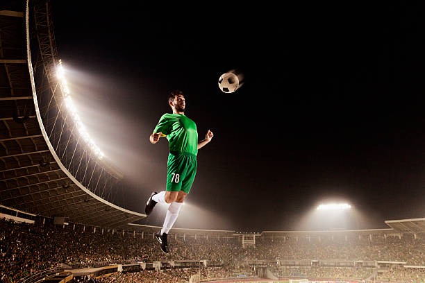 istock Athlete chesting soccer ball in stadium 518064382