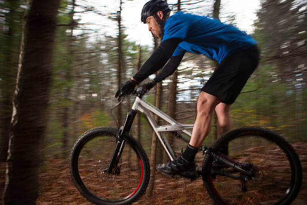 istock Mountain biker descending a trail at speed in the woods 518065814