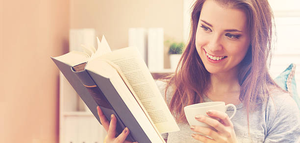 istock Happy young woman reading a book 518066904