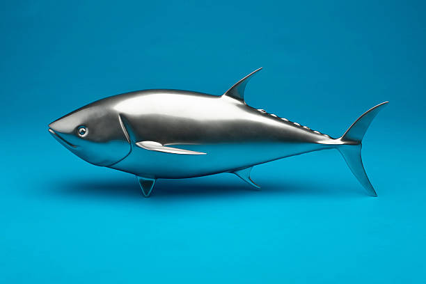 Model marine fish from metal on a beautiful blue background. Studio macro image.