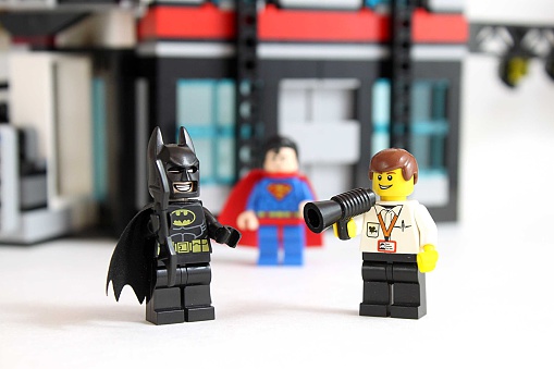 Colorado, USA - March 25, 2016: Studio shot of LEGO minifigure Batman, Superman, and a movie director with building in background.