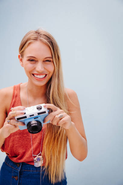 istock Pretty young girl posing while holding her camera 518069516