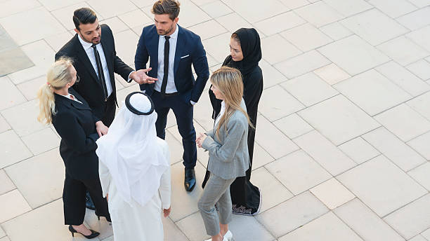 Professionals in Middle East A group of business professionals are discussing business. Higher angle view. expatriate photos stock pictures, royalty-free photos & images