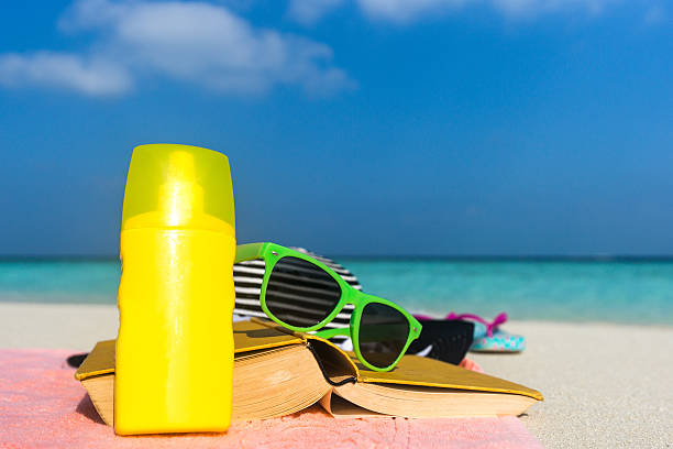 istock Sunscreen, hat and sunglasses on tropical beach 518084790