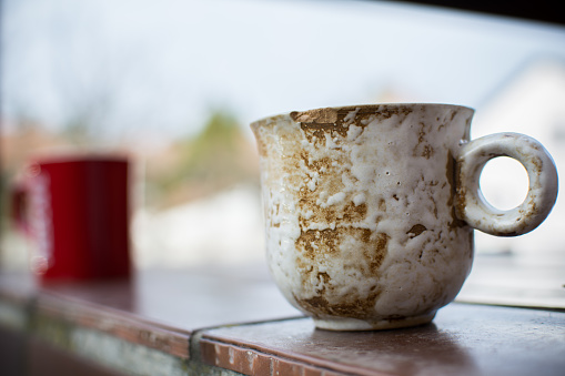 Small ceramic cup of coffee photographed outdoors