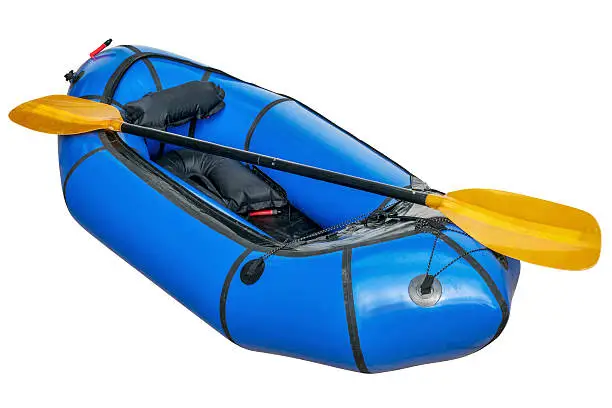 a blue packraft (one-person light raft used for expedition or adventure racing) with a paddle isolated on white with a clipping path