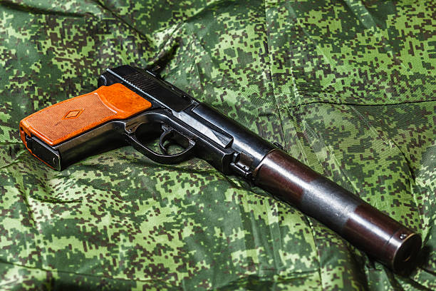 istock semi-automatic silenced pistol on pixel camouflage background 518089426