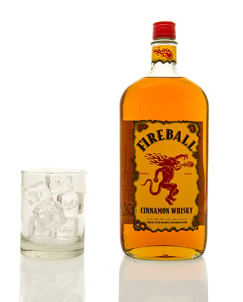 Fireball Cinnamon Whisky  Winneconne, WI, USA- 15 March 2016:  A bottle of Fireball cinnamon whisky with a glass of ice. alcoholism alcohol addiction drunk stock pictures, royalty-free photos & images