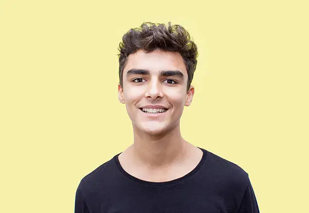 Photo of Portrait of smiling boy over yellow background