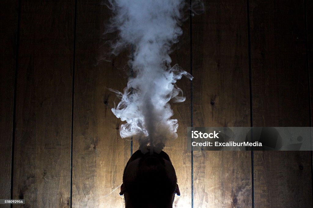 Sagoma Di Uomo Che Soffia Fumo E Vapore Verso Lalto - Fotografie stock e  altre immagini di Adulto - iStock