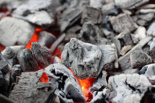 Glowing embers from burned down fire in fireplace