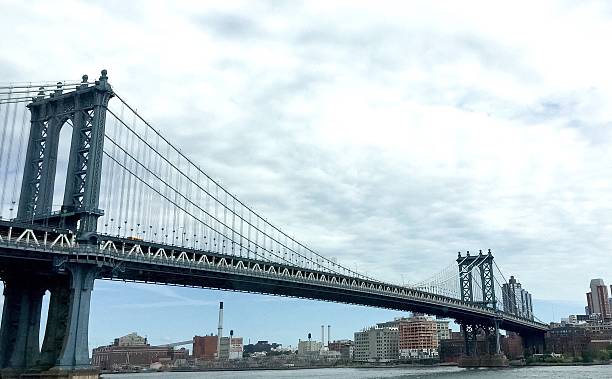 istock Manhattan bridge and the city under cloudy blue sky 518094468