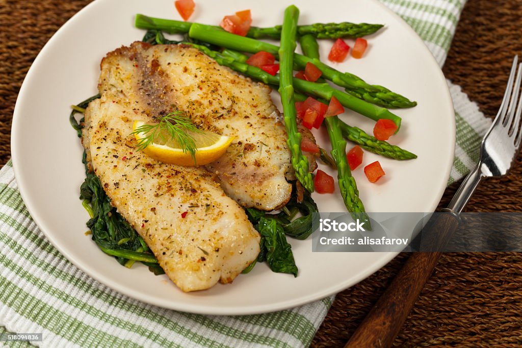 Baked Fish Fillet Whitefish with Roasted Asparagus. Selective focus. Tilapia Stock Photo