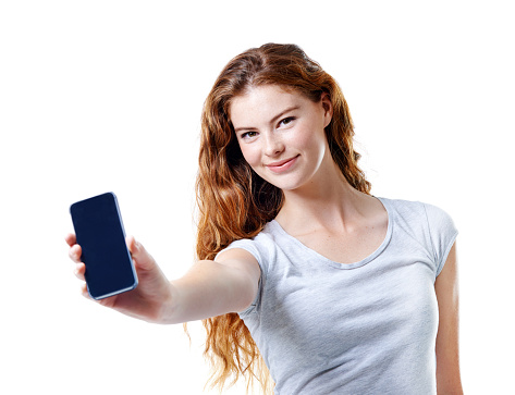 Studio portrait of an attractive young woman holding out her mobile phone